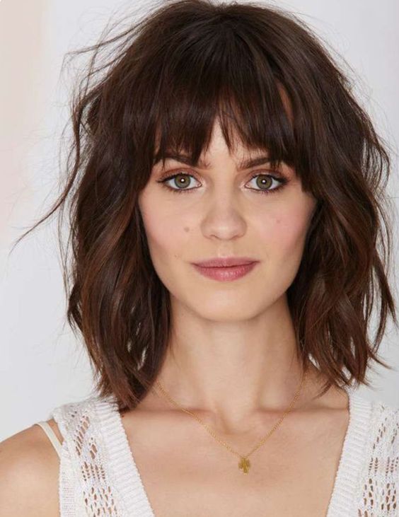 A dark brunette long bob with bottleneck bangs, waves, and a lot of dimension, a super chic and cool idea