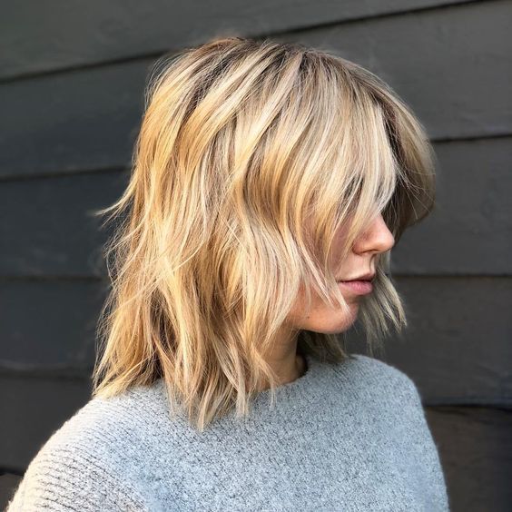 A messy blonde wavy long bob with curtain bangs is a chic and relaxed idea to rock anytime