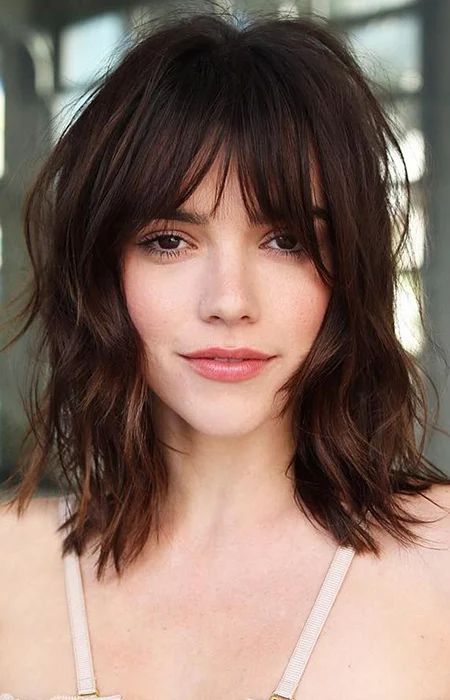 A shaggy '70s-inspired long brown bob with layers and messy overgrown bangs is a classic idea to rock now