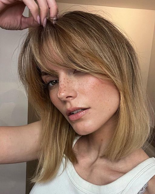 A warm and soft blonde long bob with curtain bangs is a cute and romantic idea with a very soft touch of color