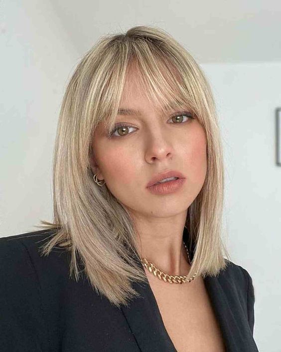 An elegant long blonde bob with wispy bangs is a stylish and chic idea to try, the color is very chic
