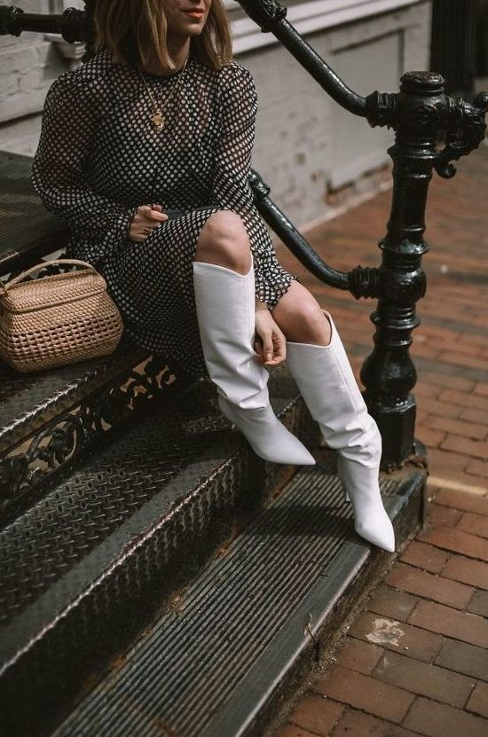 Black and white polka dot midi dress featuring long sleeves, white slouchy boots, and a basket-style bag for a chic ensemble