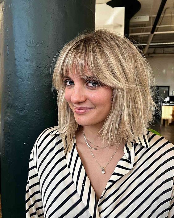 Blonde long bob with wispy bangs and messy texture, a cool and lovely solution that is effortlessly chic