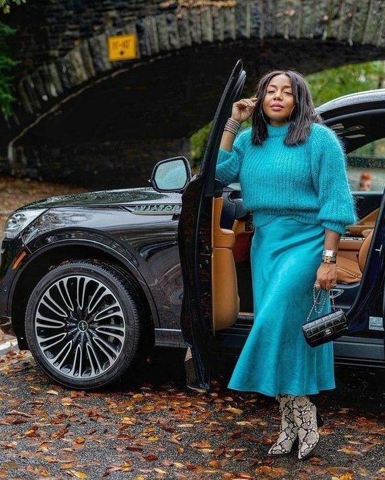 Bright look with a turquoise jumper, slip midi skirt, snakeskin print boots, and a black bag