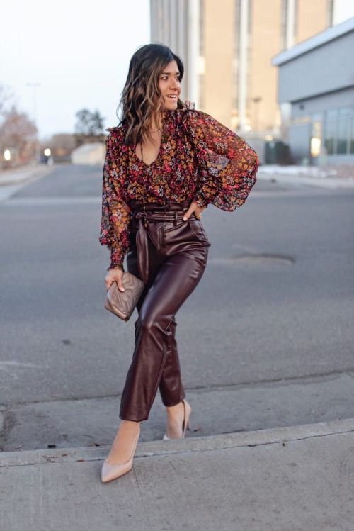Burgundy leather pants, moody floral blouse, small grey bag, and blush shoes, a cool solution for a fall wedding guest