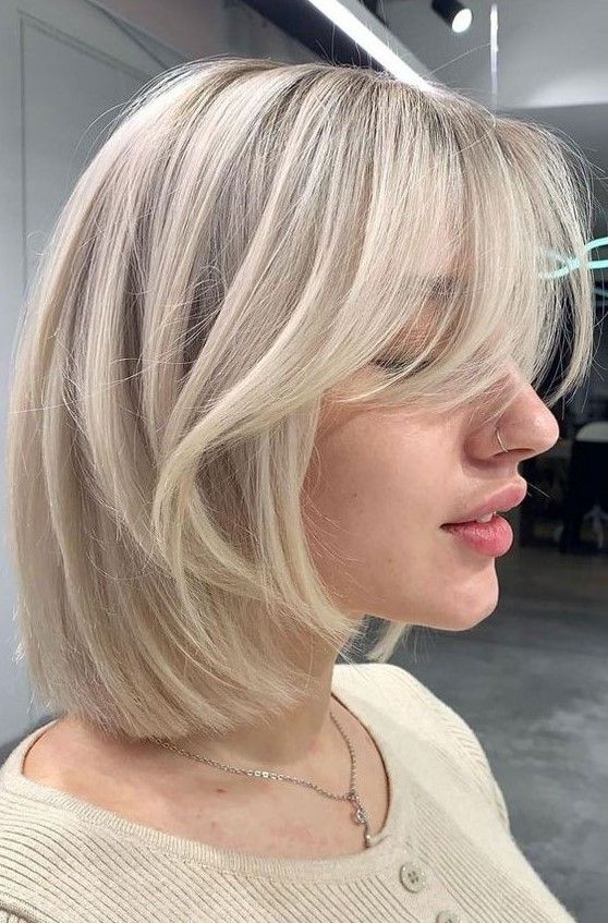 Chic icy blonde long bob with curtain bangs, a very cool idea that feels modern and edgy