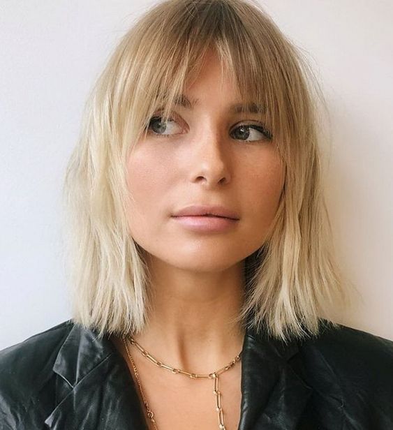 Chic long blonde bob with a darker root and curtain and bottleneck bangs, a catchy '70s-inspired solution