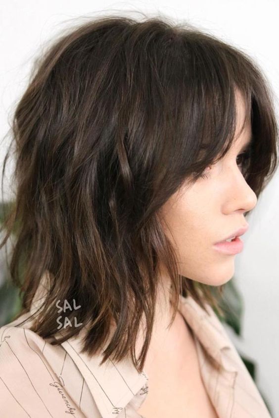 Dark brown long bob with side bangs and messy waves, a cool and modern solution to rock