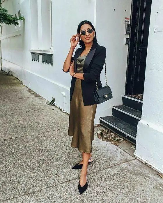 Dark gold slip midi dress, black tuxedo blazer, black slingbacks, and a small black bag, a cool look for a wedding
