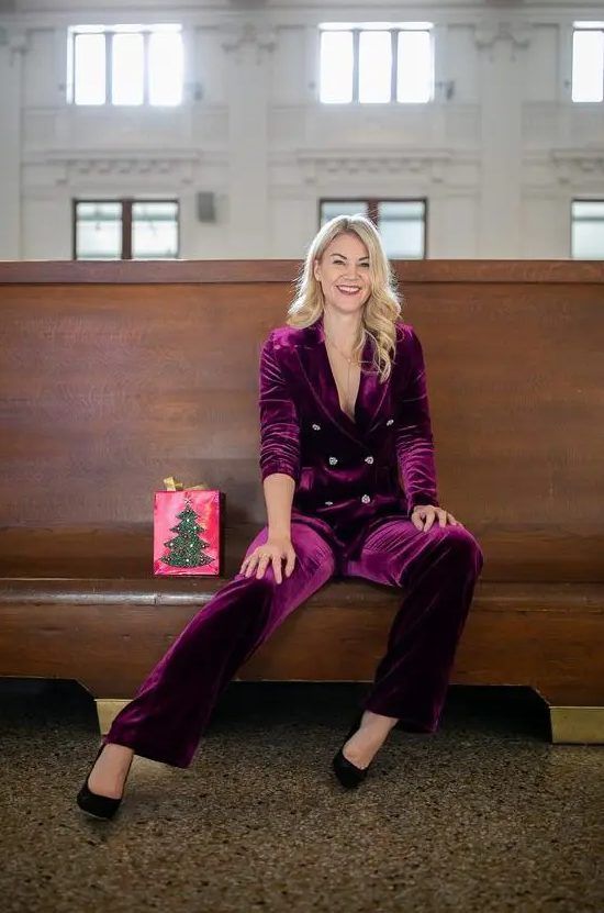 Fantastic winter guest outfit with a purple velvet pantsuit, black shoes, and a lariat necklace