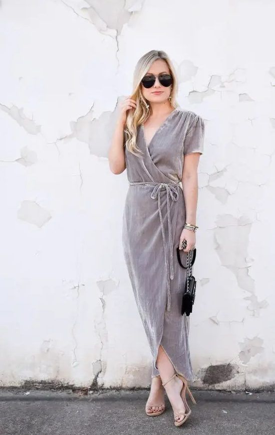Grey wrap velvet dress with long ties, short sleeves, nude heels, and a small black bag