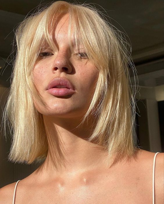 Long blonde bob with layers and bottleneck bangs, a catchy and bright idea to rock