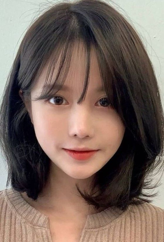 Long dark brunette bob with rounded ends and wispy bangs, a chic and beautiful idea to rock