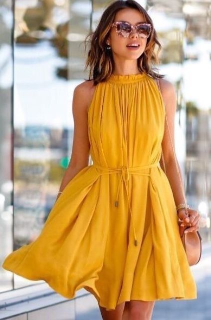 Marigold halter neckline knee dress with sashes and a brown saddle bag, for a no-fuss look