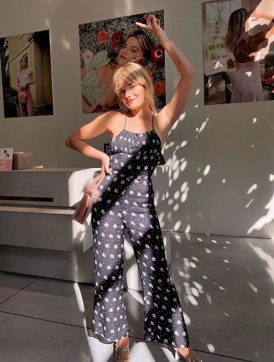 Navy printed jumpsuit with spaghetti straps, silver shoes, and a pink bag, a great combo for a summer wedding