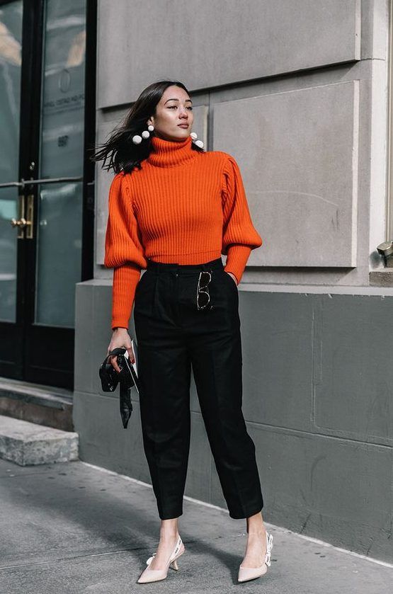 Orange sweater, black high-waisted pants, neutral shoes, statement earrings, a lovely fall look