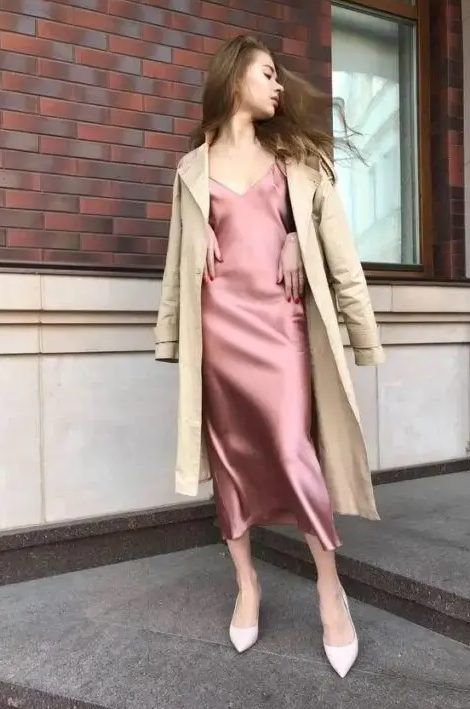 Pink slip midi dress, white shoes, and a tan trench coat for a lovely and effortlessly chic look