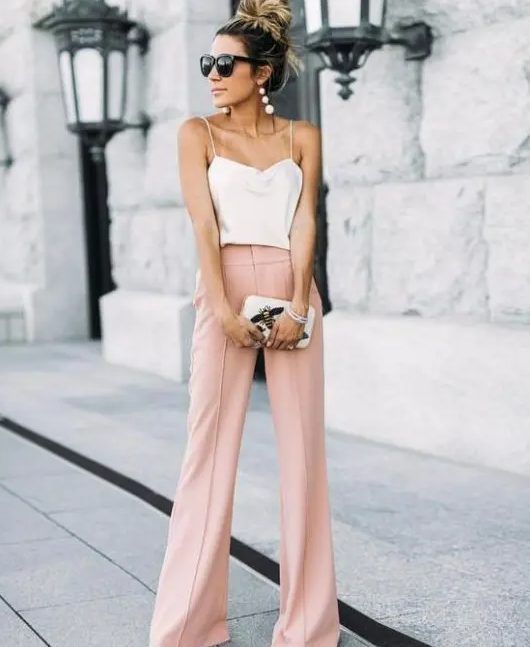 Pink wide-leg pants, creamy spaghetti strap top, statement earrings, small clutch with appliques, a casual summer wedding ensemble.