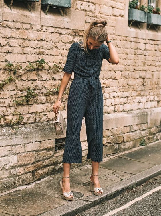 Polka dot jumpsuit with cropped pants, short sleeves, neutral platform shoes, and a small matching bag