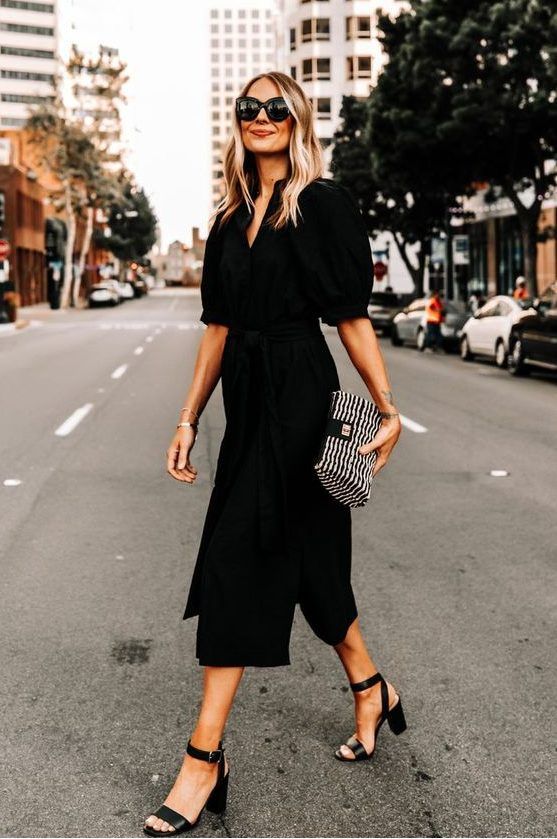Refined black midi shirtdress with puff sleeves and a deep neckline, black shoes, and a printed mini handbag