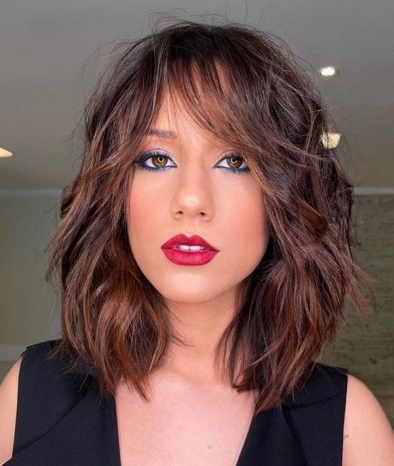 Rich brown long bob with caramel balayage and messy waves plus bottleneck bangs, a chic and catchy idea