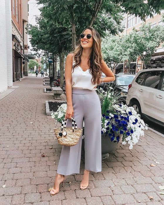 Slate grey cropped wide-leg pants, white silk top with lace, nude heels, and a wicker bag for a casual summer wedding